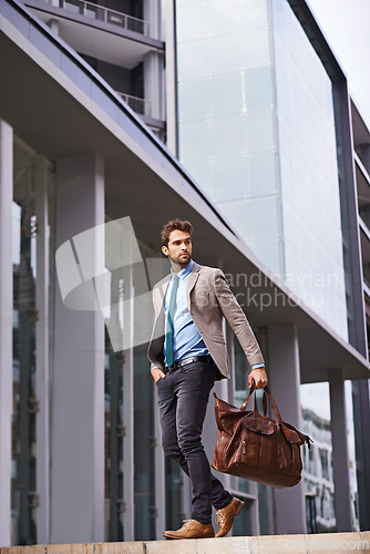 Image of Professional, walking and businessman travel in the city in suit working at the office with hands. Young, man and corporate in front of urban buildings as a worker commutes to a startup company.