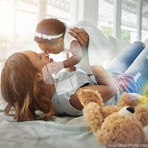 Image of Love, black woman and baby bonding on floor with kiss and happiness playing together in living room. Smile, mother and daughter in playful embrace, quality time for parent and newborn in family home.