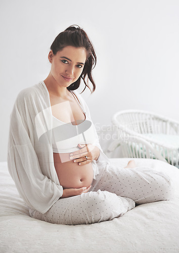 Image of Portrait, pregnant and woman on a bed, maternity leave and happiness with rest, relax and healthy. Face, female person and mother touching stomach, pregnancy and lady in a bedroom and break at home