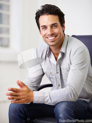 Image of Portrait, casual and man with a smile, chair and casual outfit in the workplace. Face, happy male person and gentleman with happiness, handsome and career with professional and startup success