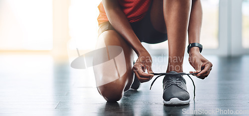 Image of Shoes, fitness and woman tying laces to start exercise, workout or wellness sport in a gym for health performance. Sneakers, banner and hands of a healthy person or runner ready for training