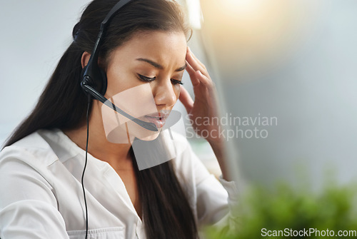 Image of Call center, face or woman with headache, stress or burnout is overworked by telemarketing deadline. Depressed, sad or tired sales agent frustrated with migraine pain in customer services office
