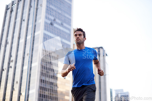 Image of Fitness, workout and man running in the city for health, wellness or training for a marathon. Sports, runner and male athlete doing an outdoor cardio exercise for endurance or speed in an urban town.