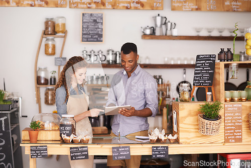 Image of Business, man and woman with a tablet, cafe and explain process with planning, schedule and talking. Partnership, entrepreneur and employees with technology, profit growth and conversation in a store