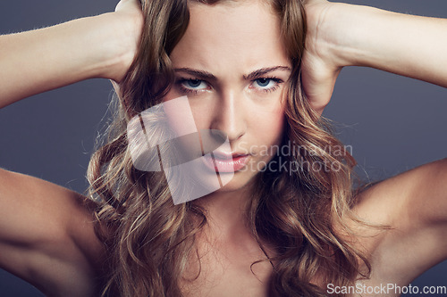 Image of Face, angry or frustrated young woman and in a studio background. Serious or concerned portrait, health wellness and female model isolated alone with headshot in backdrop for skincare or cosmetic