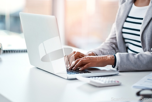 Image of Hands, businesswoman typing on laptop and in office sitting at her desk at work. Social networking or technology, business and female person type an email or write a financial report at her workplace