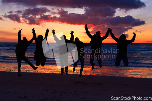Image of Beach, sunset and silhouette of jumping friends in nature, freedom and celebrating travel outdoor. Shadow, jump and group of people at the ocean and sunrise for adventure, celebration or sea vacation
