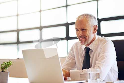 Image of Laptop, smile and research with a business man in the office, working online to finish a project at his desk. Computer, technology and email with a mature male manager at work for company strategy