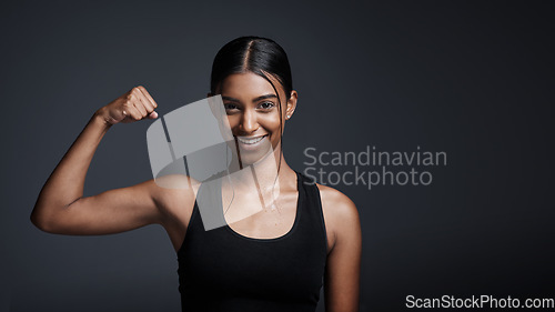 Image of Portrait, smile and woman flexing bicep in studio isolated on a black background mockup space. Strong, happy and female athlete with muscle, arm strength and bodybuilder ready for fitness workout.