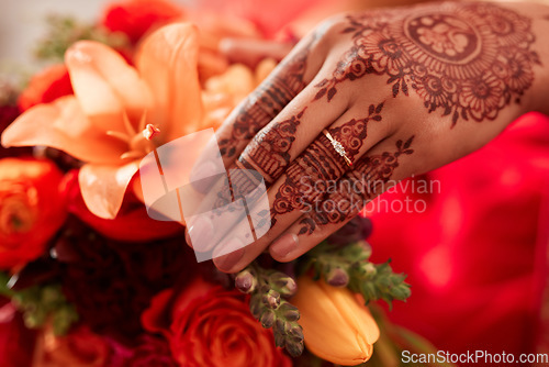 Image of Henna, hand and Indian bride at her wedding event with flowers or bouquet for decoration or design. Event, marriage and creative female person or woman with art pattern on her hand for celebration