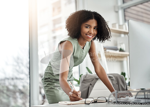 Image of Planner, writing and portrait of business woman by her desk or table and standing in a corporate startup company. Internet, online and African professional female employee with schedule notebook