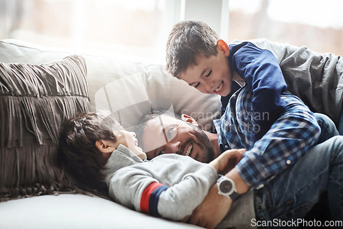 Image of Father, boy children and laughing together, fun and carefree with love, energy and happy at family home. Man play with kids on sofa, crazy and playful with happiness and excited with laughter