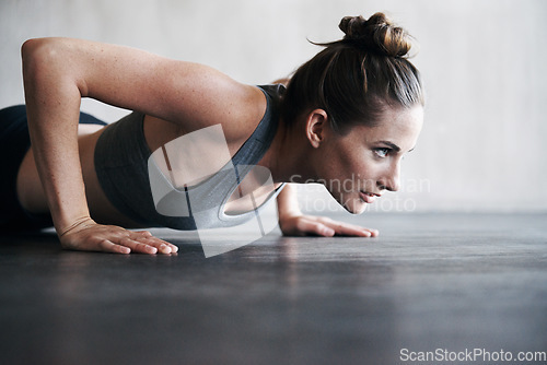 Image of Fitness, pushup and woman on a floor for training, cardio and endurance at gym. Lifting, exercise and female athlete at a health center for core, strength and ground workout with determined mindset