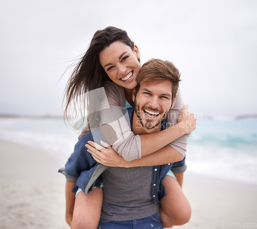 Image of Couple, portrait and piggyback hug at beach for travel, romance and freedom together outdoors. Face, smile and happy woman embracing man on trip, vacation or holiday, bond and having fun in Florida