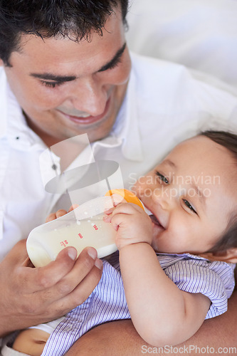 Image of Baby laugh, feeding and dad with child at home with a bottle of milk with happiness with kids. Family, young child and drink for growth and development with father bonding and happy in a house