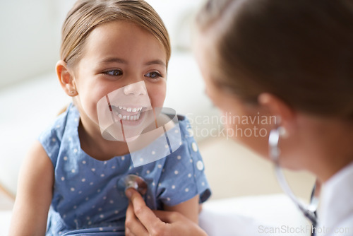 Image of Happy girl, kid and pediatrician with stethoscope for medical consulting, healthy lungs and listening to heartbeat. Face of child, doctor and chest assessment, healthcare analysis and smile in clinic