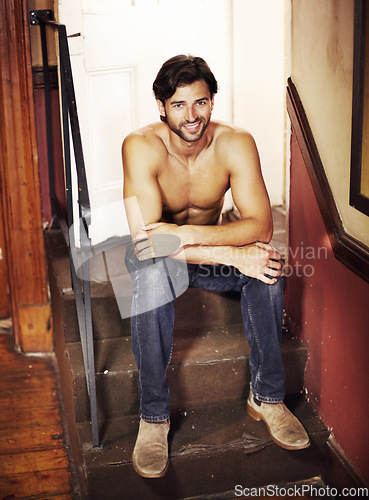 Image of Happy portrait, shirtless and a sexy man on stairs with a smile, confidence and positive mindset. A happy male model person sitting on steps for art deco, fitness and fashion in apartment or house