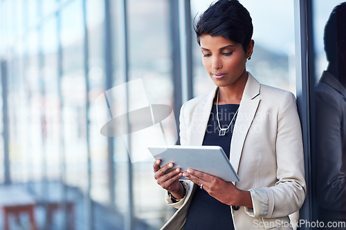 Image of Tablet, mockup and corporate with a business woman leaning against a glass wall or window at the office. Technology, research and space with a young professional female employee working online