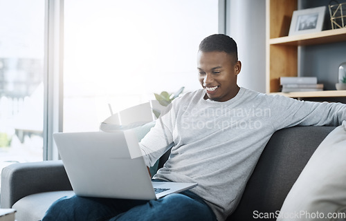 Image of Black man with laptop, streaming online and relax in living room, subscription service with internet and happiness. Technology, connectivity and male person chill at home watching movie on sofa