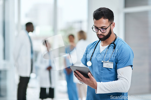 Image of Medical, doctor and tablet with a man in a clinic reading healthcare and wellness data at hospital. Employee, nurse and Indian male person with digital and health results on technology with research