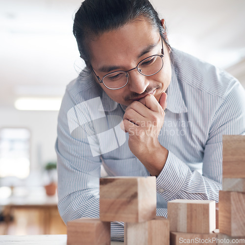 Image of Thinking, ideas and Asian man in office with building blocks, strategy game and design balance with innovation. Engineering, architecture and designer with idea, wood block game and problem solving.