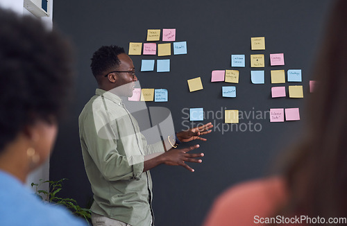 Image of Meeting, brainstorming and planning with team, black man speaker, sticky note and leader in presentation. Collaboration, teamwork and people in strategy workshop, ideas with presenter and audience