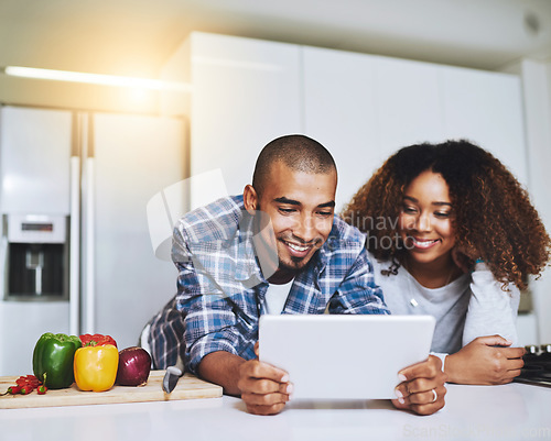Image of Couple, tablet and cooking food in kitchen at home with blog, internet website and online connection. Happy African man, woman and digital recipe for reading instruction of healthy vegetarian meal