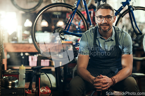 Image of Portrait, smile and technician man in bicycle shop, store or cycling repair workshop. Face, bike mechanic and male person, confident business owner or mature professional from Canada with glasses.