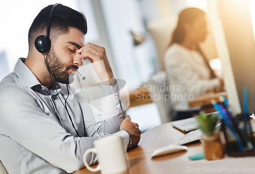 Image of Headache, tired or man in call center with burnout, head pain or overworked in crm communication. Migraine, office or stressed telemarketing sales agent frustrated with anxiety, fatigue or problem