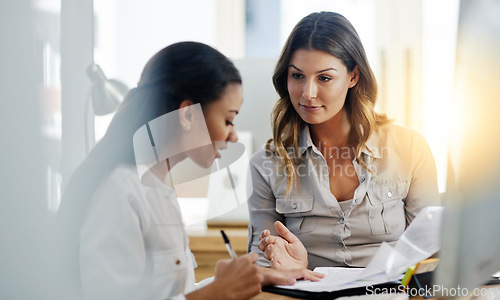 Image of Business women, notebook and partnership with discussion, planning or paperwork in office together. Woman, teamwork and talking with documents, notes or schedule in workplace for collaboration at job