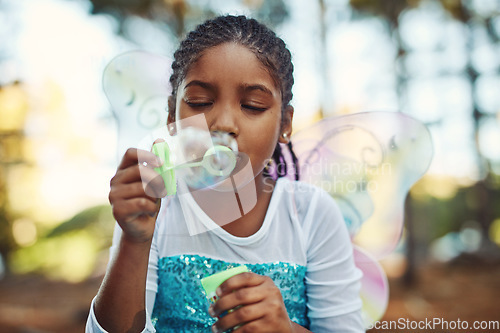 Image of Forest, princess costume and girl with bubbles for playing fantasy, childhood games and happiness. Nature, fairy tale and face of happy child in woods blowing bubble for adventure, magic and fun