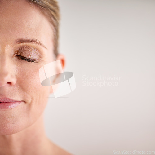 Image of Beauty, mockup and half face with a woman in studio on a gray background for cosmetic skincare advertising. Facial, wellness and eyes closed with a senior female model posing for natural skin care
