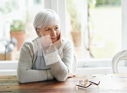 Image of Senior woman, home and thinking of nostalgia, memory and relaxing retirement with hope for vision at table. Happy elderly grandma daydream of history, aging process and wisdom of thoughtful memories