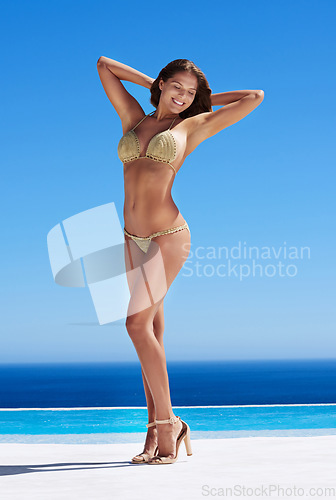 Image of Beach, travel and woman in a bikini and heels while on summer vacation, holiday or adventure. Happy, fashion and full length of sexy female model posing in swimwear by ocean on tropical weekend trip.