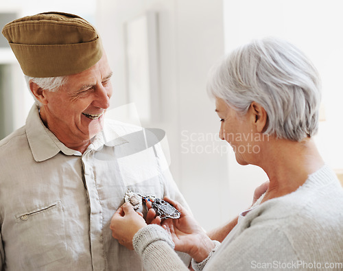 Image of Military veteran, man and woman with medal, uniform and smile together with memory, pride and success. Elderly couple, army badge or regalia with happiness, check and retirement from service in house