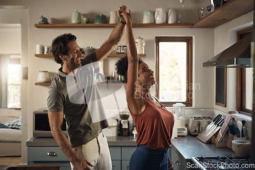 Image of Interracial couple, happy and dance in kitchen for fun bonding, love or holiday together at home. Man and woman dancing in joyful happiness for relationship, romance or enjoying weekend in the house