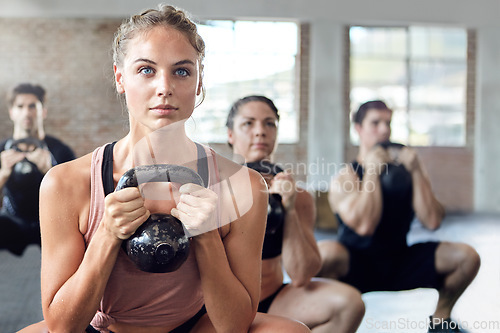 Image of Fitness, kettlebell and personal trainer doing a workout with a group for strength training in a gym. Sports, challenge and female coach doing a exercise with weights with people in a wellness center