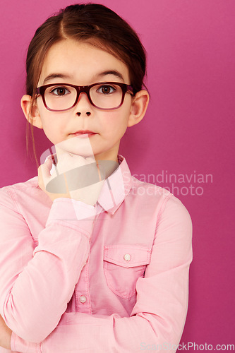 Image of Girl child in portrait, glasses and thinking with questioning expression, smart and vision isolated on pink background. Intelligent, geek or nerd with female kid in studio, thoughtful in eyewear