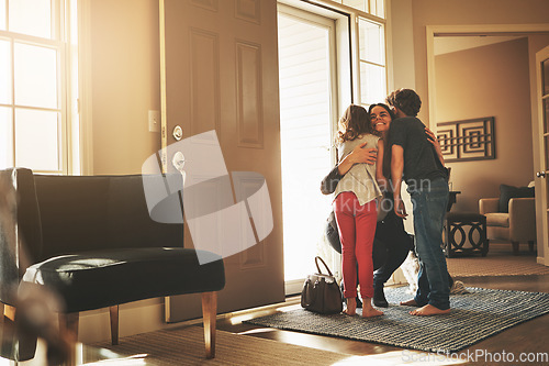 Image of Home, love and a mother hugging her kids after arriving through the front door after work during the day. Greeting, family or children with a woman holding her son and daughter in the living room