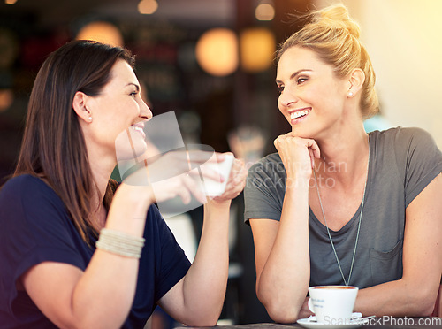 Image of Conversation, cafe and female friends drinking coffee together while talking and bonding for gossip. Happy, smile and women speaking, laughing and enjoying a warm beverage at a restaurant in the city