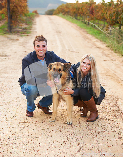 Image of Portrait, nature and a couple walking their dog outdoor on a dirt road while bonding together for love. Happy, agriculture or sustainability with a man and woman taking their pet for a walk on a farm