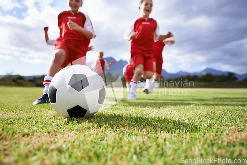 Image of Running, closeup and sports with children and soccer ball on field for training, competition and fitness. Teamwork, summer and action with football player on pitch for goals, energy and kids game