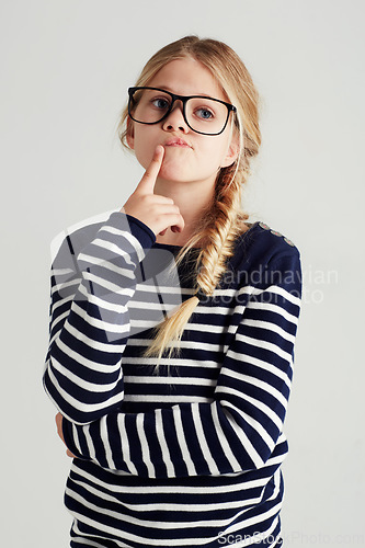 Image of Thinking, focus and girl with ideas, future and fantasy against a grey studio background. Female child, smart kid and young person with thoughts, wonder and fantasy with concentration and daydreaming