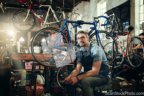 Image of Portrait, wrench and serious repair man in bicycle shop, store or cycling workshop. Face, bike mechanic and male person, business owner or mature professional technician with glasses and confidence.