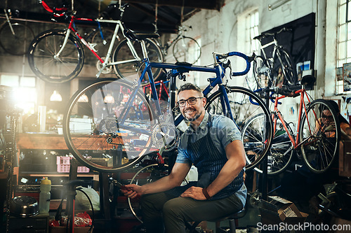 Image of Portrait, wrench and smile of repair man in bicycle shop, store or cycling workshop. Face, bike mechanic and male person, happy business owner or mature technician with glasses and confidence.