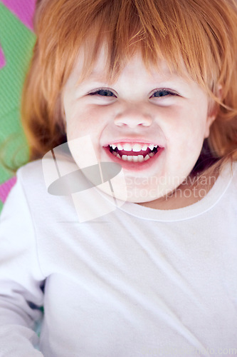 Image of Young girl, laughing and funny portrait of a baby on a home playpen ground with a smile. Ginger infant, kid laugh and happy in a house with joy, youth and positivity from childhood looking up