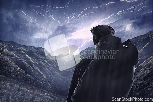 Image of Lightning storm, travel and a man hiking from the back in the mountains during the night with winter rain. Dark sky, gray clouds and stormy weather with a male hiker outdoor in dangerous conditions