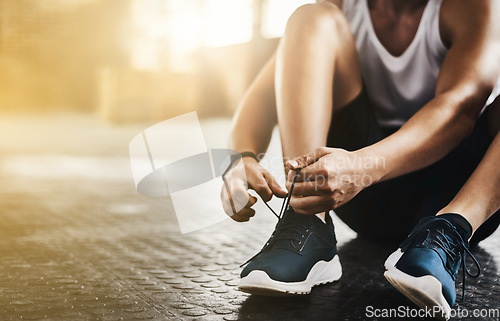 Image of Fitness, gym and man tie shoes before a workout for health, wellness and endurance training. Sports, healthy and closeup of male athlete preparing while tying laces before a exercise in sport center.