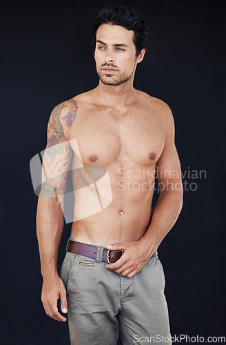 Image of Model, man and muscle with tattoo on body in jeans for motivation with dark background. Male person, healthy and strong with sexy chest for training or shirtless after workout or exercise.