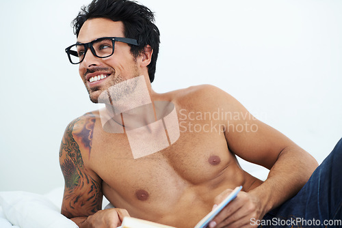 Image of Book, happy shirtless young man with glasses and on a bed in white background. Nerd or smart, male model with sexy body and smiling person topless in his home or apartment with notebook for reading